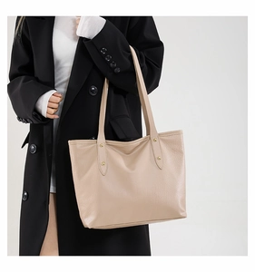 Dettaglio della borsa tote beige in ecopelle con trama coccodrillo e borchie dorate