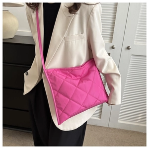 Detailed view of magenta quilted tote bag showing rhombus stitching and shoulder strap