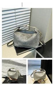 Close-up of light gray crossbody bag with vintage washed texture and gold metal hardware