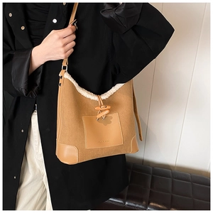 Detail of vintage canvas bucket bag with plush lamb hair trim and leather brand patch