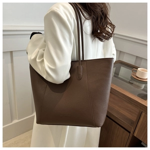 Detail of dark brown lychee pattern tote bag with shoulder strap in minimalist setting