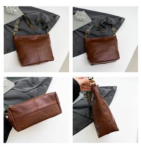 Close-up of retro brown leather tote bag with wide bohemian jacquard woven strap