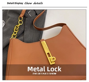 Detail einer karamellbraunen Ledertasche mit goldener Schnalle und grober Metallkette