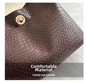 Close-up of deep brown woven texture and polished gold round swivel lock on the bag