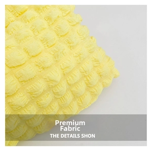 Detailed close-up of vibrant yellow bubble textured fabric on a stylish puffer cloud bag