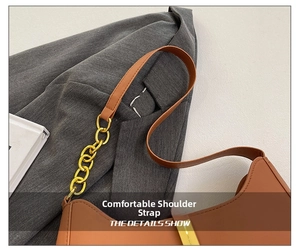 Detail eines braunen Leder-Schultergurts mit goldener Gliederkette einer schicken Handtasche