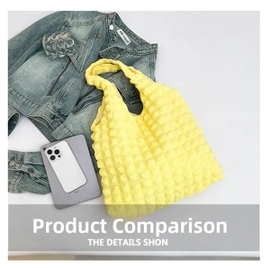 Detail of a bright yellow tote bag with bubbly texture next to a tablet and jacket