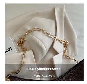 Close-up of a dark brown woven shoulder bag with a textured finish and gold chain strap