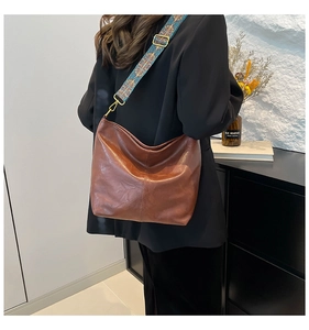 Detail of brown hobo bucket bag with a patterned bohemian wide shoulder strap