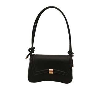 Minimalist black leather underarm bag with curved wave base and gold buckle on white background
