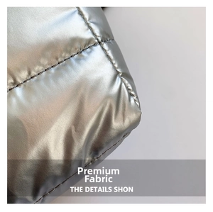 Detailed close-up of quilted metallic silver fabric with high-gloss finish and stitching