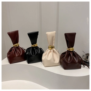Détail de sacs seaux plissés rétro en quatre couleurs avec anneaux métalliques dorés