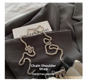 Close-up of silver metal chain strap with plush cream fabric and black leather details