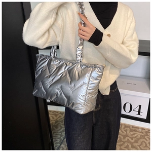 Detailed view of silver quilted tote bag with metallic texture and ruched shoulder strap