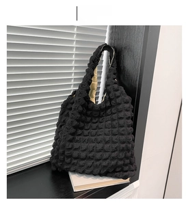 Detailed view of black puffy cloud tote bag with popcorn texture by a window