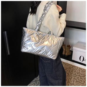 Silver quilted tote bag with puffer texture and ruched shoulder strap shown on model