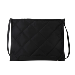 Minimalist black quilted tote bag with diamond pattern and slim shoulder strap