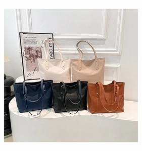 Dettaglio di borse tote in pelle testurizzata in cinque colori con rivetti dorati eleganti