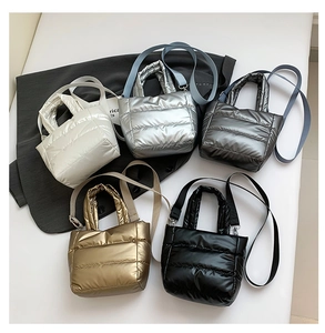 Detailed view of quilted puffer handbags in five metallic colors with detachable straps