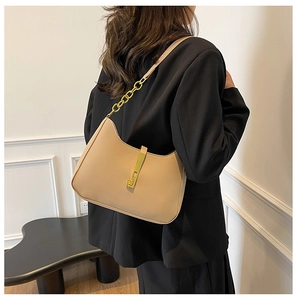 Detail showing the golden metal clasp and chain links on a beige hobo shoulder bag