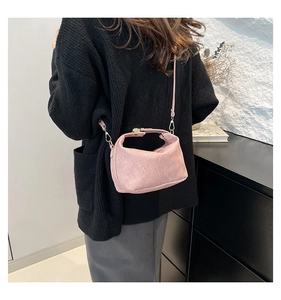 Detailed view of pink suede crossbody bag featuring elegant metallic hardware and thin strap