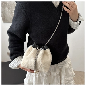 Détail du sac seau en peluche crème avec chaîne argentée et cordon élégant à perles