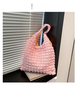 Detail view of the light pink bubble textured fabric and soft interior of the tote bag
