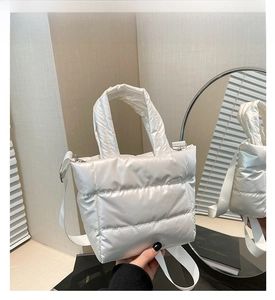 Detailed shot of white quilted puff tote bag with soft padded handle and long strap