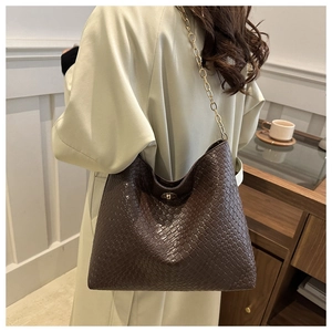 Detail of dark brown woven leather hobo bag with gold chain strap and metal lock closure