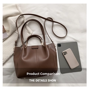 Detail of dark brown leather tote bag with tablet and phone for size reference