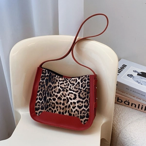 Leopard print and red PU suede bucket bag with stylish shoulder strap in a minimalist setting