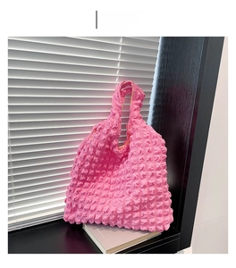 Detail of deep pink puffer tote bag showing unique 3D bubble texture and pleated fabric