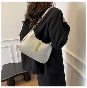 Detail of silver metallic leather handbag with gold chain strap and clasp hardware