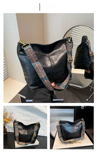 Detail view of large black bucket bag with a colorful ethnic jacquard wide shoulder strap
