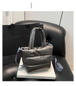 Detail of grey quilted down tote bag with metallic finish and adjustable strap