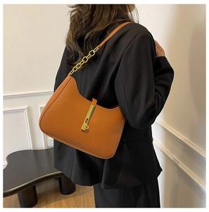 Detail of caramel half-moon hobo bag with gold metal buckle and leather strap