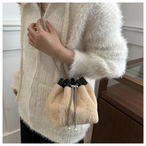 Detail of plush bucket bag with faux pearl drawstring and silver chain strap