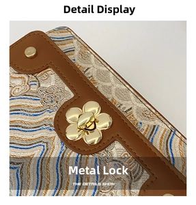 Détail macro du fermoir doré en fleur de prunier sur tissu jacquard à fleurs