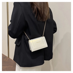 Detail of pearl white mini bag with gold chain strap and FASHION & BAGS lettering