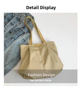 Detail of beige pleated canvas tote bag with fashion label and textured fabric straps