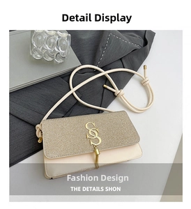 Close-up of beige crossbody bag with textured patchwork and golden tassel detail