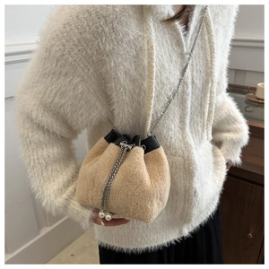 Détail du sac seau en fausse fourrure avec bandoulière chaîne et accents de perles chic