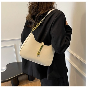 Detail of a chic off-white underarm bag with gold metal buckle and leather chain strap