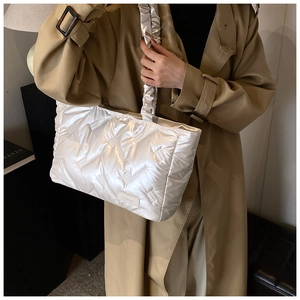 Detail of white quilted tote bag with pleated ruffles handle and khaki trench coat outfit