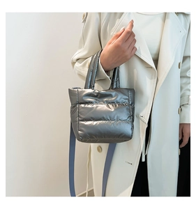 Detail of metallic silver quilted puffer bag showing the plush texture and shoulder strap