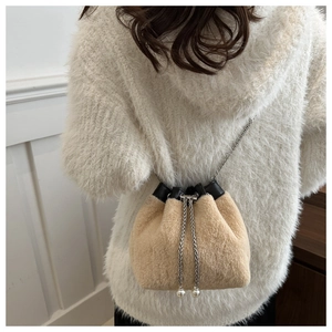 Detailed view of plush faux fur bucket bag with silver chain and pearl drawstring charms