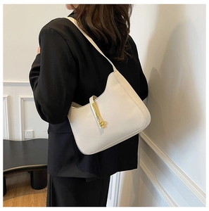 White leather hobo bag with gold vertical metal clasp shown on female model in black blazer