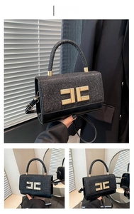 Detail of black sequined patchwork handbag featuring a prominent gold metal logo clasp