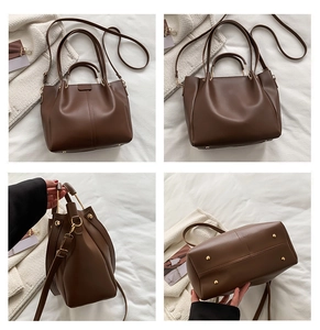 Detail view of brown tote bag with metal circular handle and protective metal bottom studs