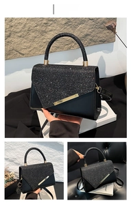 Detail of black sequined flap handbag with gold metal accents and leather strap
